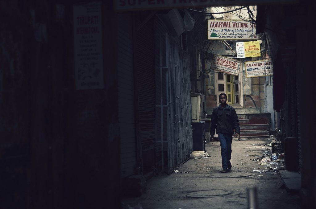 A child walking down a deserted lane in an Indian town.